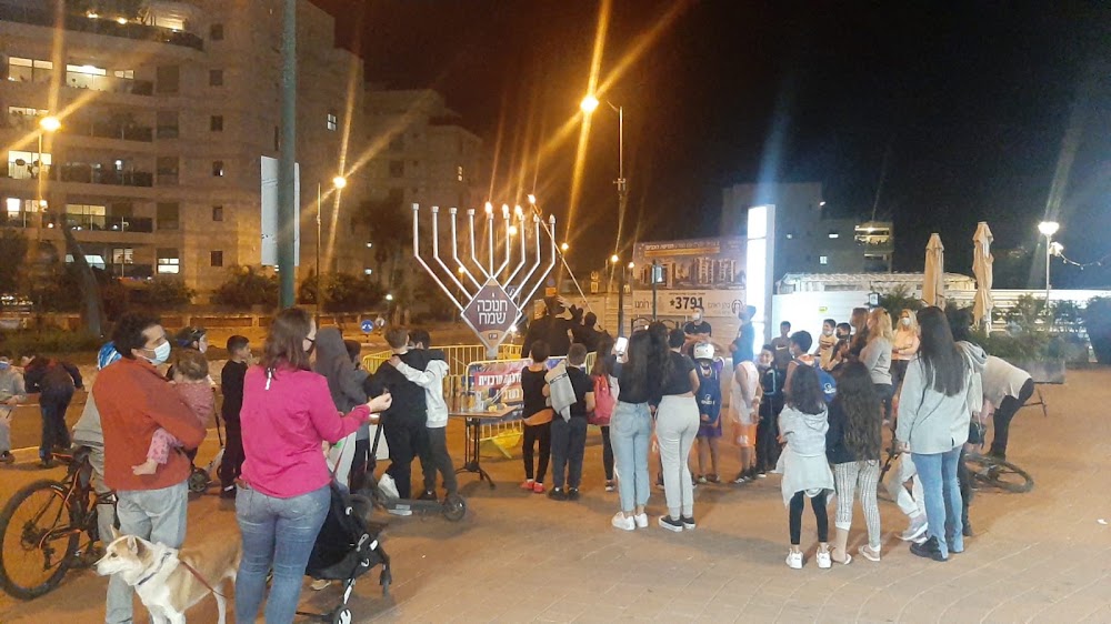 קהל סביב חנוכייה מוארת
